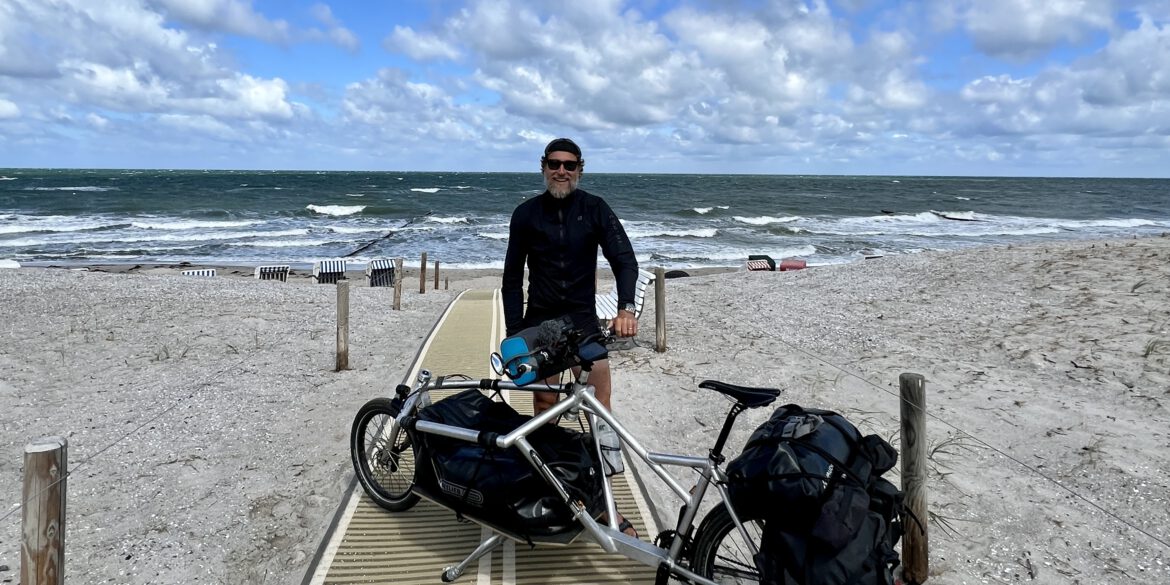 Markus Knüfken am Strand mit Fahrrad